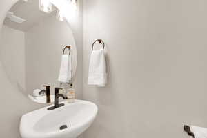Half Bathroom with updated lighting and faucet.