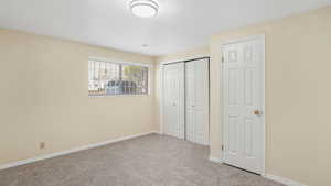 Unfurnished bedroom with carpet floors, a closet, and baseboards