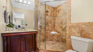 Full bath with a stall shower, vanity, and toilet