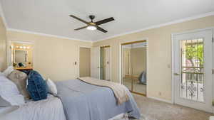 Bedroom featuring multiple closets, light carpet, and ornamental molding