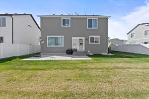 Rear view of property featuring a patio area, a fenced backyard with 2 gates, and a trampoline