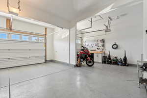 Garage featuring a workshop area and access to the backyard