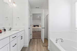 Primary bathroom with double sinks, water closet and separate tub & shower with abundant natural light