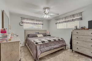 Bedroom with ceiling fan, baseboards, and light colored carpet