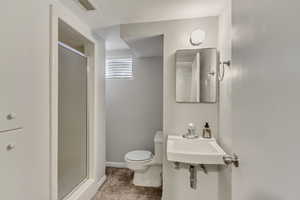 Full bathroom featuring a shower stall, a sink, baseboards, toilet, and visible vents