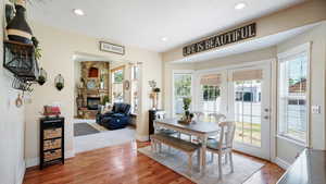 Dining space with recessed lighting, baseboards, wood finished floors, and a fireplace