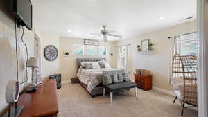 Bedroom featuring visible vents, light carpet, a ceiling fan, and baseboards
