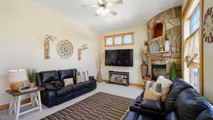 Living room with a fireplace, carpet flooring, baseboards, and a ceiling fan