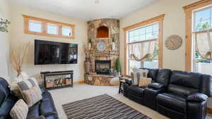 Carpeted living area with a healthy amount of sunlight and a fireplace