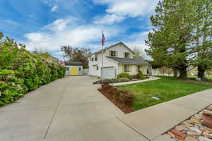 Traditional home with a front lawn, a shed, driveway, an outbuilding, and a garage