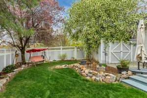 View of yard featuring a fenced backyard, an outdoor structure, and a storage unit