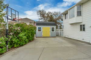 Exterior space with a storage shed, fence, and an outdoor structure