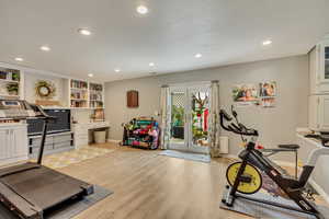 Exercise room with french doors, baseboards, recessed lighting, and light wood-style floors