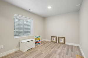 Interior space with light wood finished floors, visible vents, and baseboards