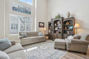 Living room featuring a towering ceiling and wood finished floors