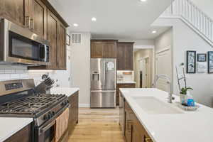 Kitchen featuring appliances with stainless steel finishes, visible vents, recessed lighting, and a sink