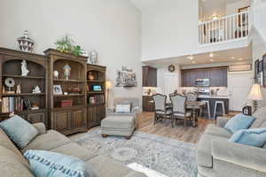 Living room with light wood-style flooring and a high ceiling