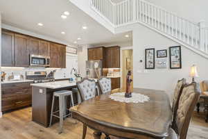 Dining area featuring recessed lighting, visible vents, a towering ceiling, and light wood-type flooring