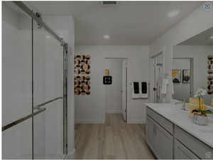 Full bathroom featuring visible vents, a shower stall, a sink, and wood finished floors