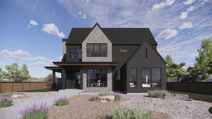 Rear view of house with fence, stone siding, board and batten siding, and covered porch