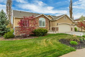 Single story home featuring stucco siding, stone siding, and concrete driveway