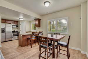 Dining space with light wood-type flooring and baseboards