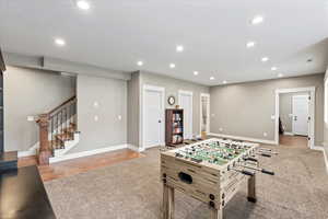 Basement family room with carpet floors, baseboards, and recessed lighting