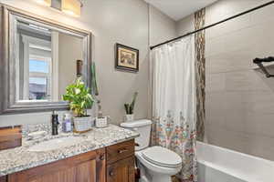 Bathroom with toilet, vanity, and shower / bathtub combination