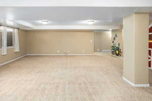 Finished basement featuring baseboards, carpet flooring, and visible vents
