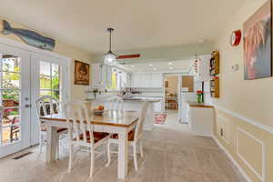 Dining area featuring french doors, visible vents, and a wainscoted wall
