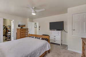 Bedroom with baseboards, light colored carpet, and ceiling fan