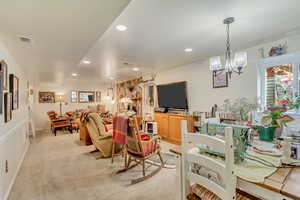 Living room with light carpet, visible vents, an inviting chandelier, and recessed lighting