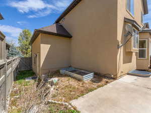 View of side of property with stucco siding, a fenced backyard, and a patio