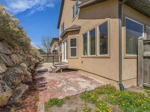 View of home's exterior with stucco siding, fence, and a patio area