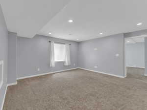 Carpeted empty room featuring baseboards and recessed lighting