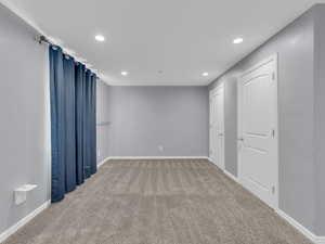 Carpeted spare room with baseboards and recessed lighting