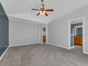 Unfurnished bedroom featuring baseboards, ensuite bath, carpet flooring, and a ceiling fan