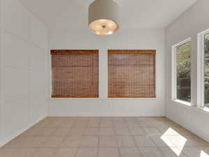Empty room featuring baseboards and light tile patterned floors