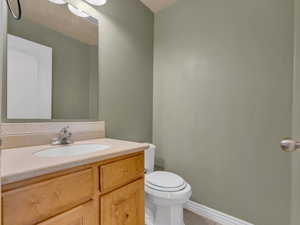 Bathroom with toilet, vanity, and tile patterned floors