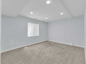 Carpeted empty room featuring baseboards, visible vents, and recessed lighting