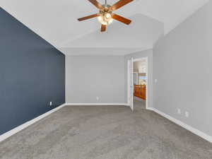 Interior space with a ceiling fan, baseboards, and vaulted ceiling