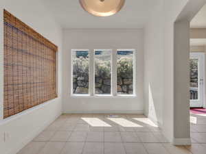 Spare room with baseboards, visible vents, and light tile patterned floors