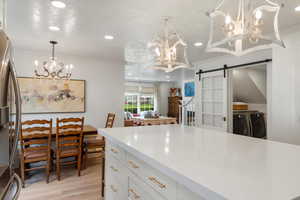 Kitchen featuring freestanding refrigerator, a chandelier, and crown molding