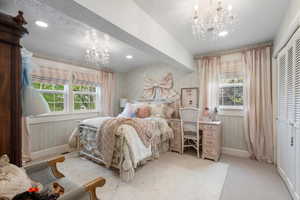Bedroom featuring wallpapered walls, baseboards, an inviting chandelier, and multiple windows
