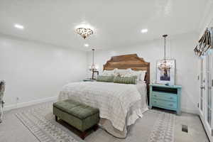 Bedroom with light carpet, ornamental molding, a chandelier, and recessed lighting
