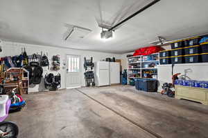 Garage featuring freestanding refrigerator and a garage door opener