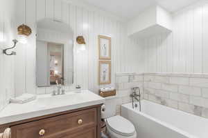 Bathroom featuring crown molding, a garden tub, toilet, and vanity