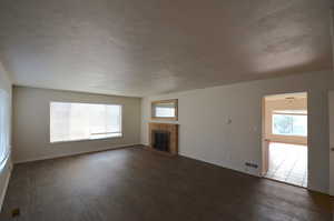 Main entrance living room - Wood fire place, brand new flooring and two large windows for natural light.