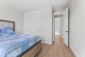 Bedroom featuring a closet, light wood finished floors, and baseboards