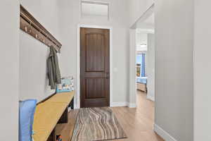 Mudroom featuring light wood-style flooring and baseboards